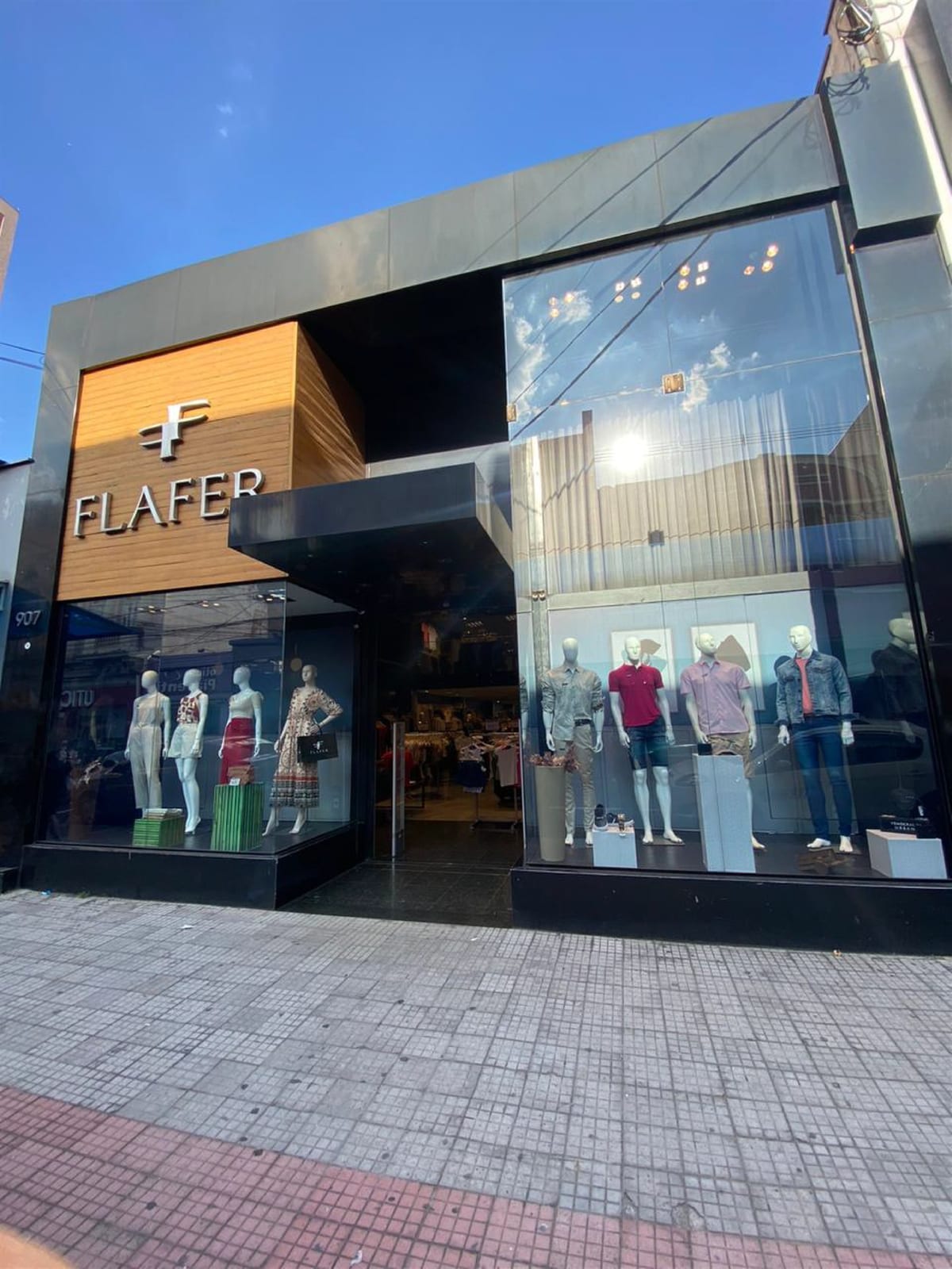 Fachada da unidade Flafer Geo, na R. Governador Pedro de Toledo, 907, com painel de madeira, letreiro FLAFER e vitrines de moda feminina e masculina